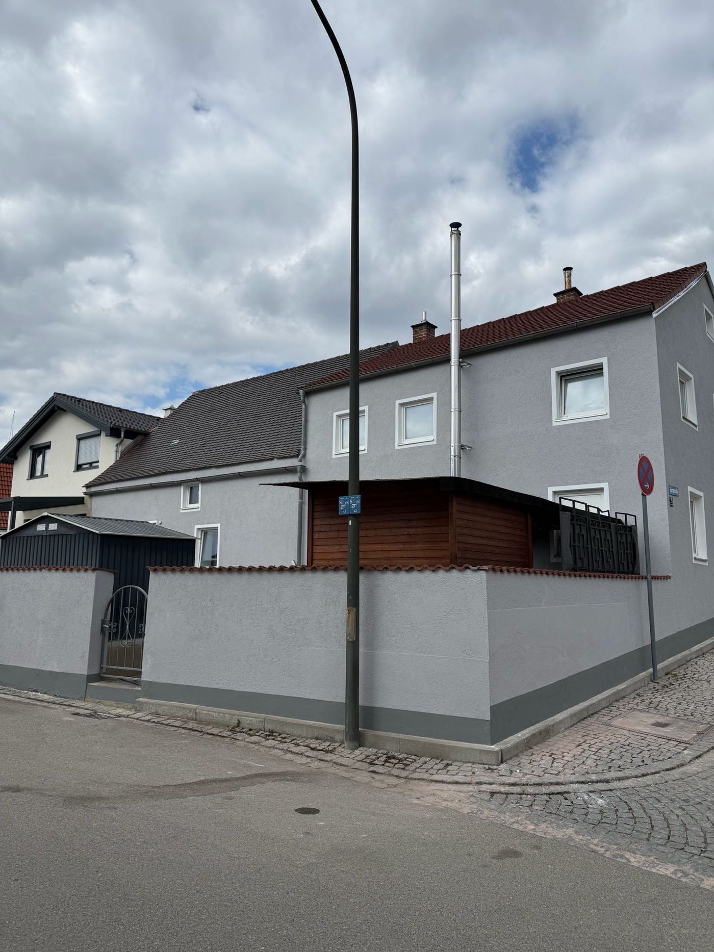 Fassade eines Altbaus nach dem Neuanstrich in hellem Grau mit weiß abgesetzten Fenstern
