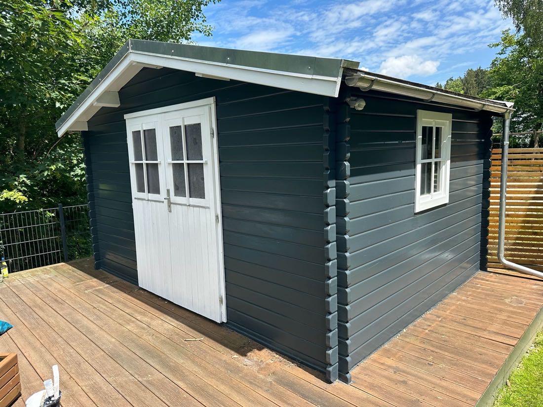 Gartenhaus in Anthrazit mit weißer Doppeltür, weißem Fenster und Holzterrasse