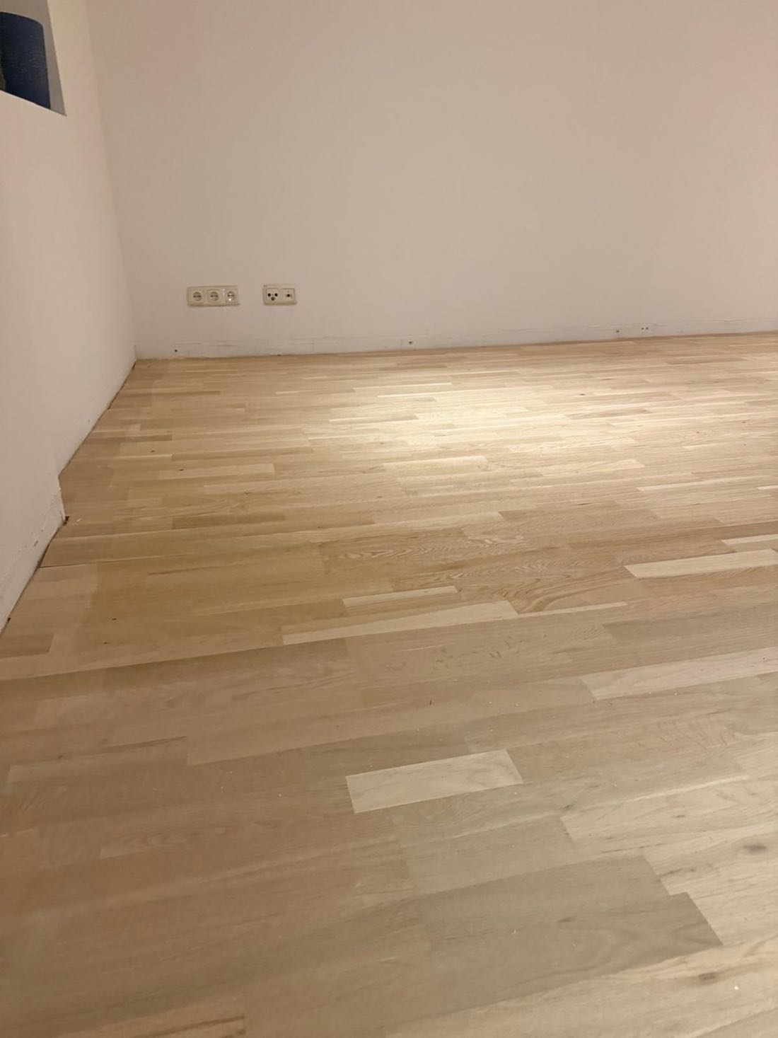 Detailaufnahme eines frisch verlegten Holzbodens in hellem Eichenton