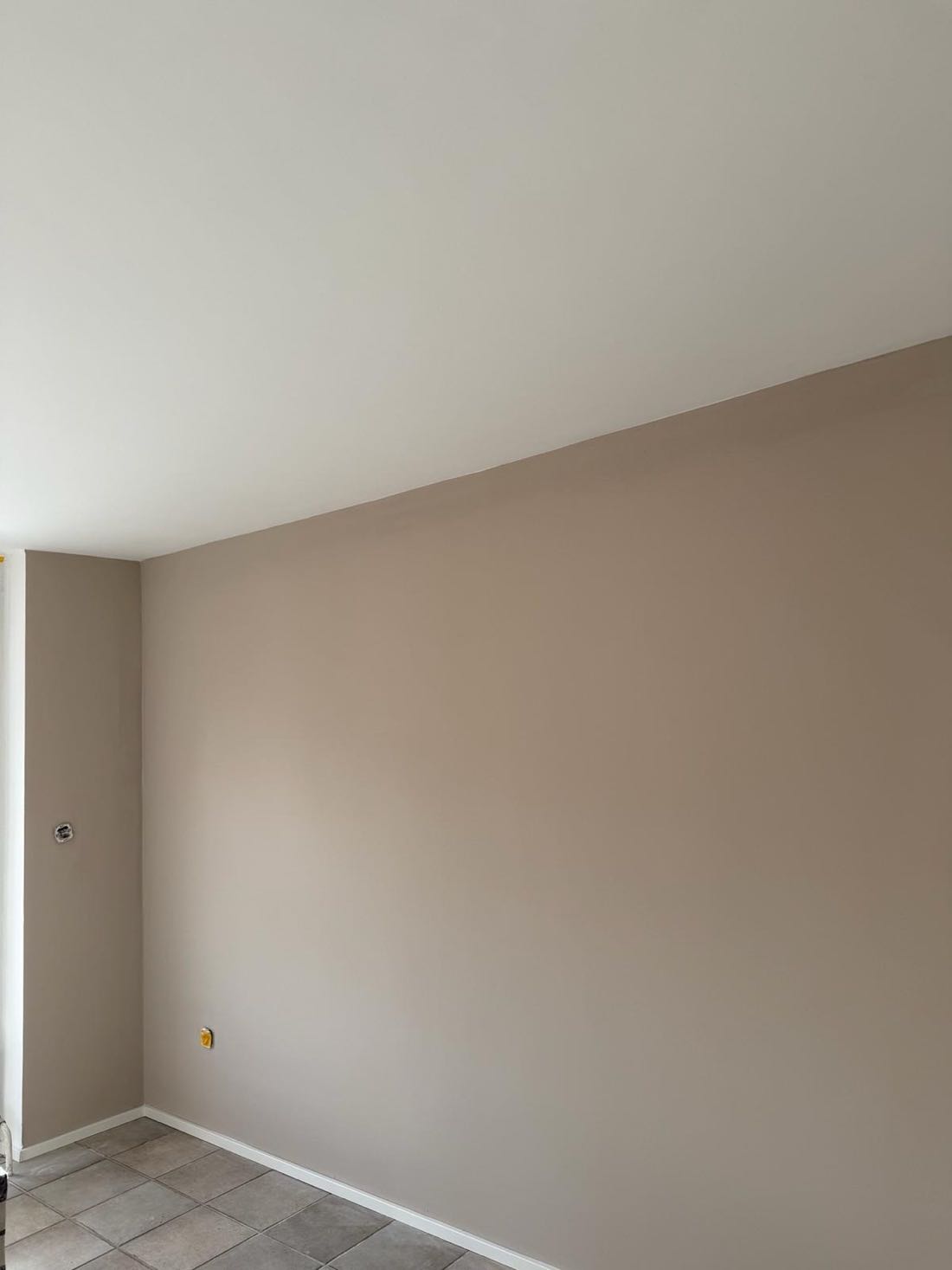 Sauber ausgeführte Kante zwischen weißer Decke und taupefarbener Wand