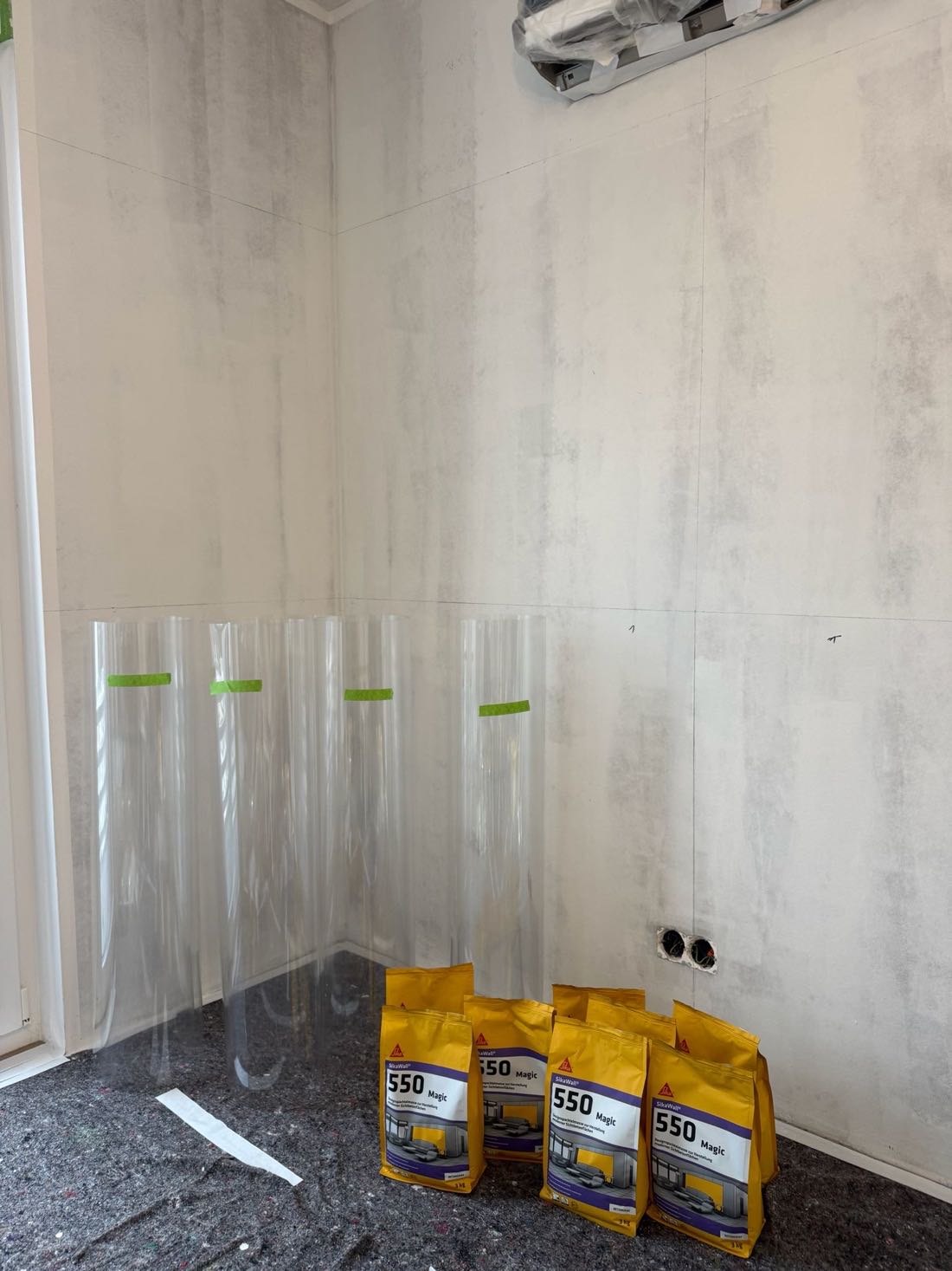 Vorbereitete Wandfläche mit Abklebungen und bereitgestelltem Spachtelmaterial
