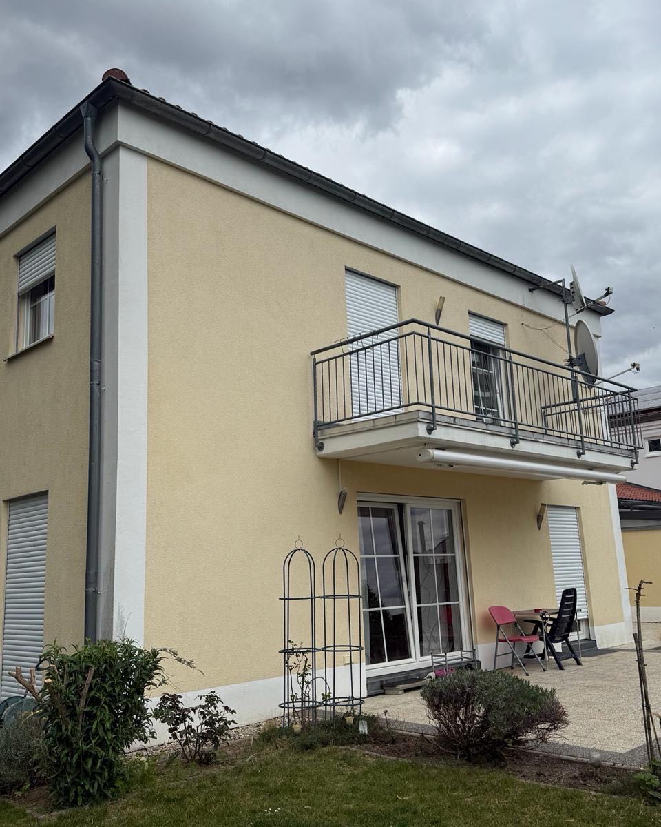 Wohnhaus mit vergilbter Fassade in Hellgelb vor der Sanierung