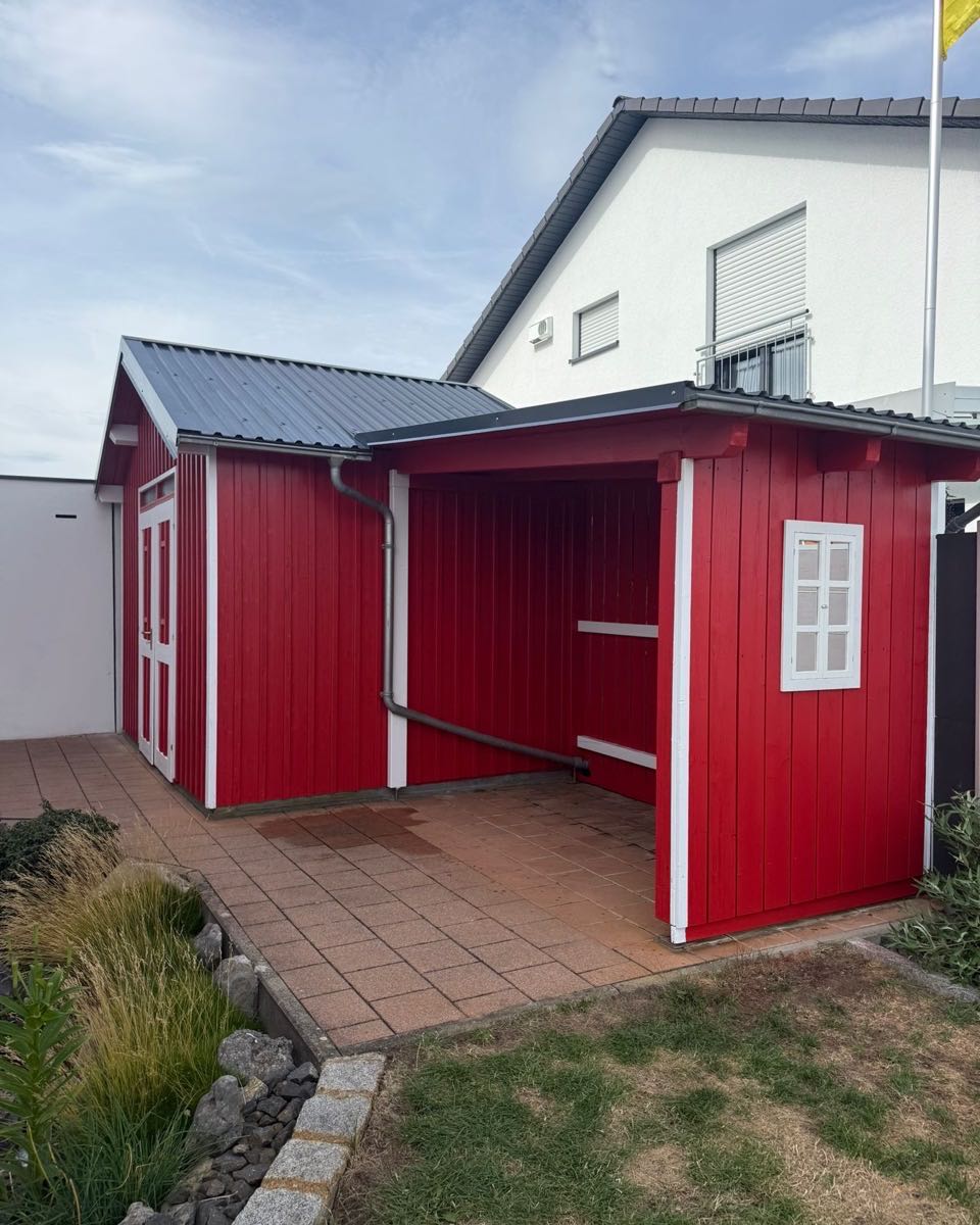 Dasselbe Gartenhaus nach dem Anstrich in Rot mit weißen Leisten
