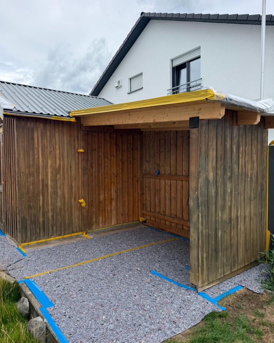 Gartenhaus mit verwittertem Holz und abgeklebten Kanten vor dem Anstrich